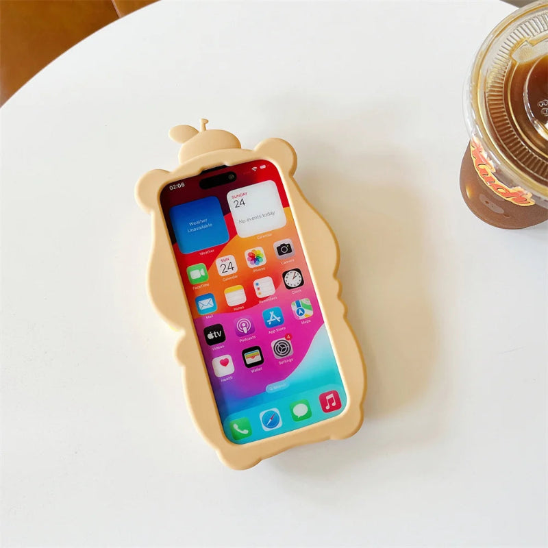 Phone with a capybara-shaped case on a white surface next to a cup of coffee