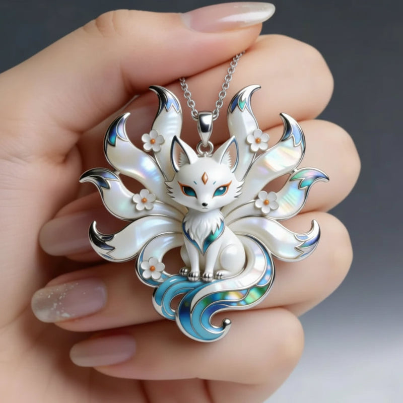 Silver Kitsune pendant with floral details held in a hand against a neutral background