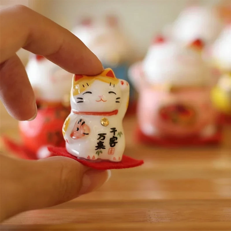 Maneki-neko figurine held by a hand with blurred background