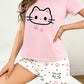 Person wearing a pink t-shirt with a kawaii cat face design and white shorts with cat face and paw prints on a plain background.