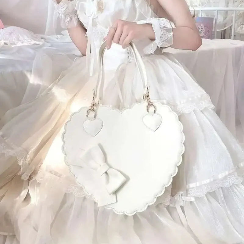 Person in a white dress holding a matching white heart shaped handbag.