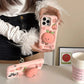 Rear view of Kawaii Peach iPhone Cases being held by a woman and on the countertop 