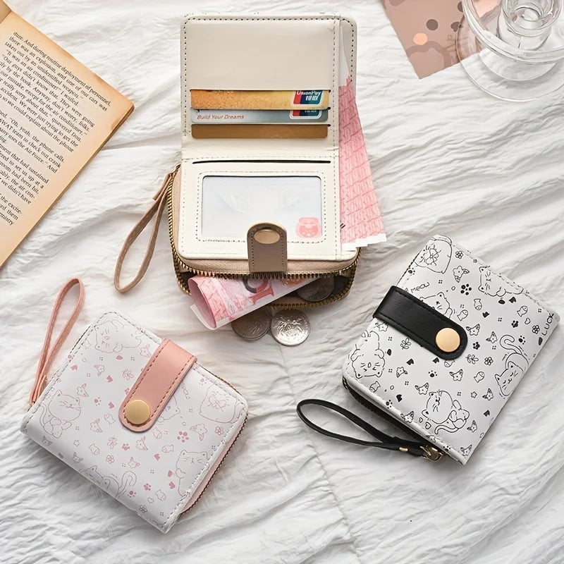 Three small wallets with cute cat designs on a textured surface