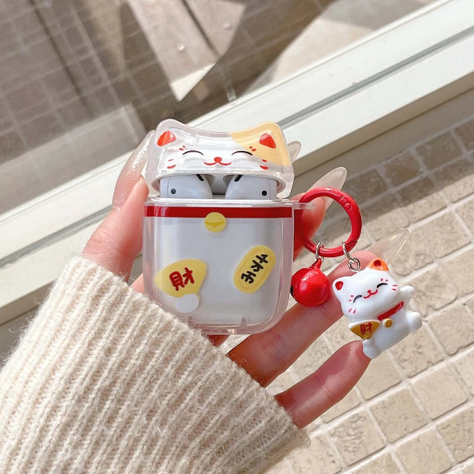 Hand holding a cute maneki neko airpod case with a matching keychain against a neutral background.