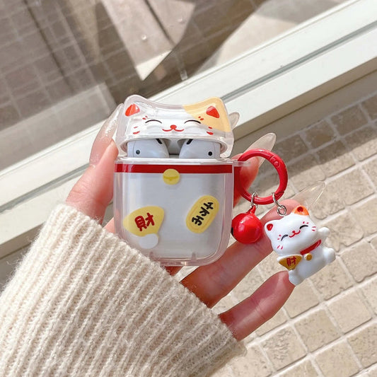 Hand holding a cute maneki neko airpod case with a matching keychain against a neutral background.