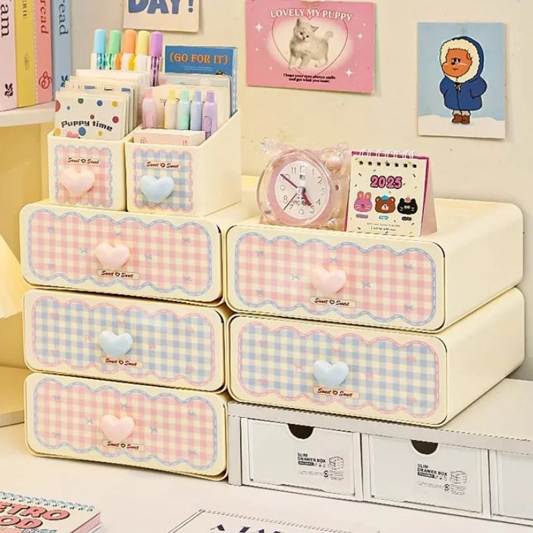 Kawaii pastel-colored storage drawers with decorative elements on a shelf.