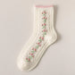 White sock with floral embroidery on a light gray background