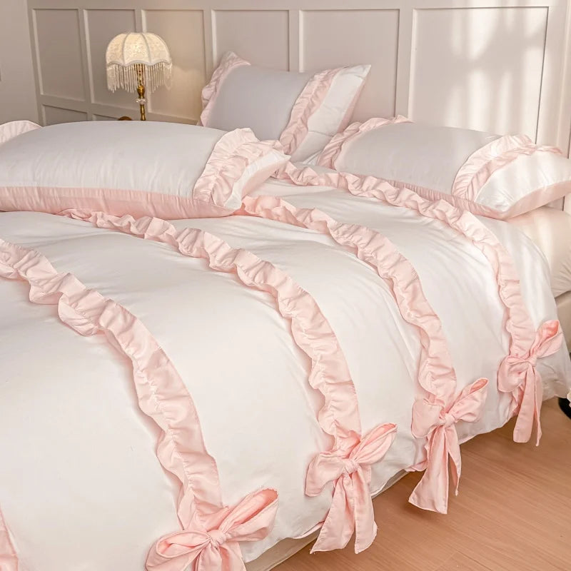 White duvet cover with pink bows and ribbons on a bed in a bedroom setting.