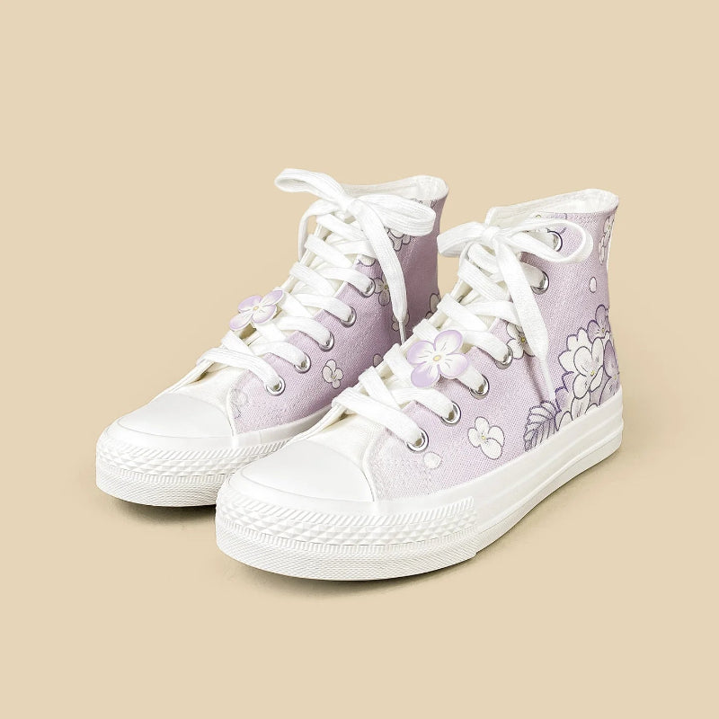 A pair of high-top canvas sneakers in light lavender purple with white laces, white rubber toe caps and soles, and a floral pattern on the side, set against a solid beige background.