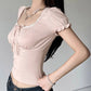 Woman wearing a cute light pink top and dark blue jeans against a plain background