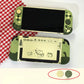 Green gaming console with cartoon designs on a white surface