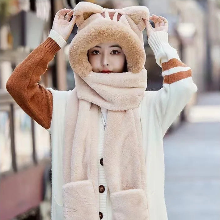 Person wearing a fluffy hat with cat ears and a scarf in an urban setting.