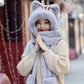 Person wearing a kawaii gray cat-themed hat and scarf on a blurred street background