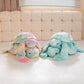 Plush blue and pastel turtle being displayed on a white matress