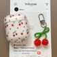 White air pod case with cherry pattern and cherry keychain