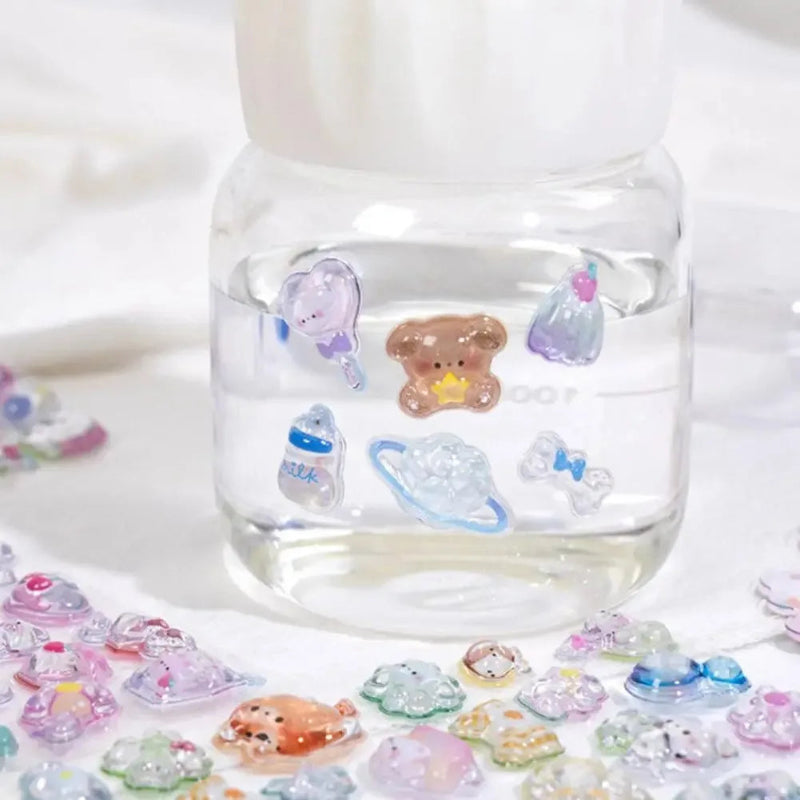 Clear glass container with colorful bear-shaped stickers on a white background