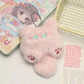 Pink plush keychain with cartoon character on a surface