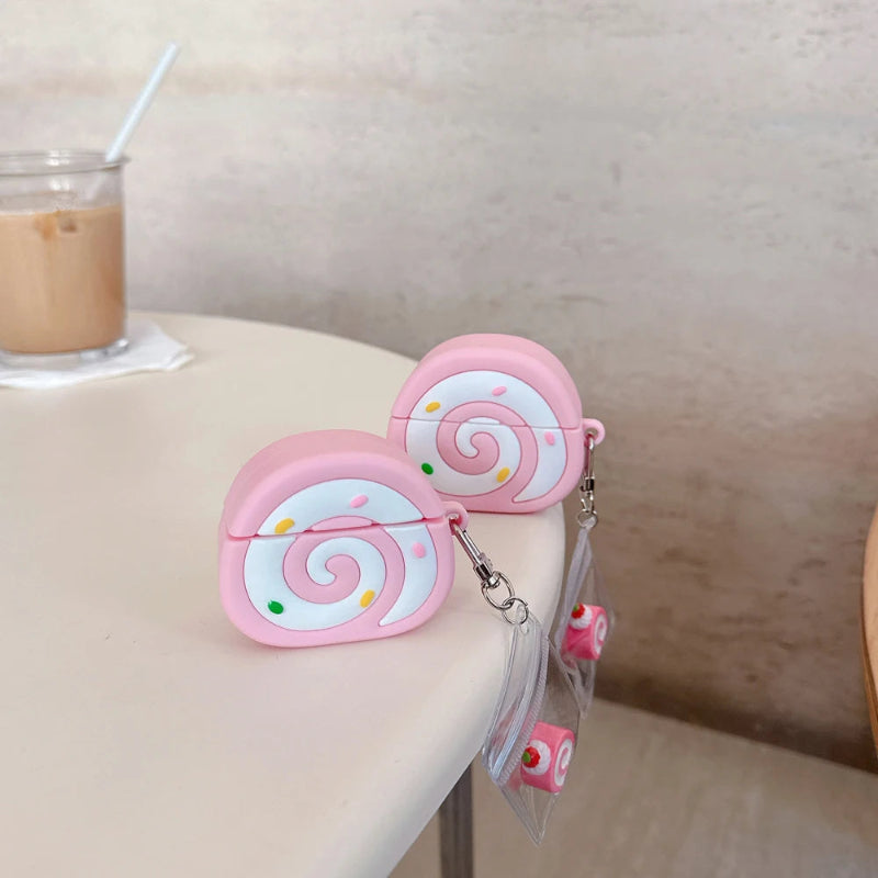 Pink swiss roll shaped air pod case with a blurred indoor background