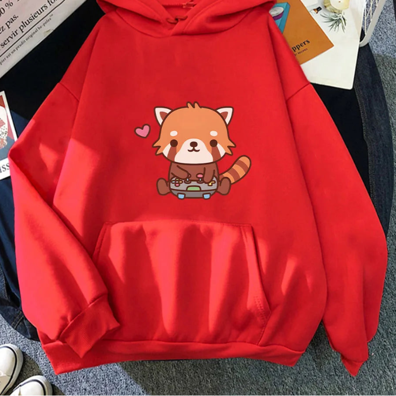 Red hoodie with a cartoon red panda design on a surface with books and a magazine.