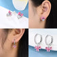 Collage of pink bow earrings with heart and crystal details on a white background.