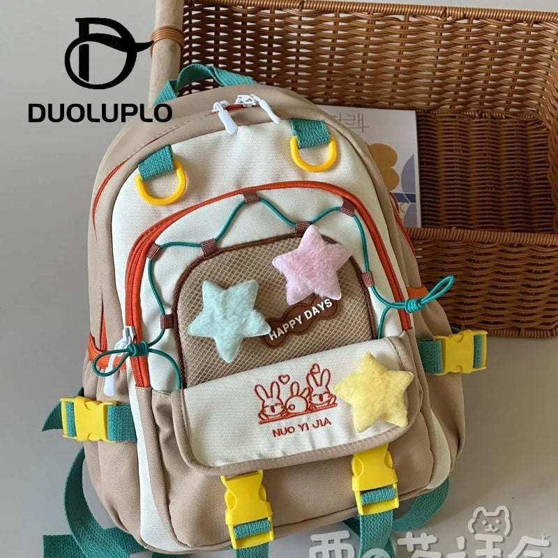 Kawaii  backpack with star-shaped features on a gray background.