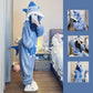 Person wearing a blue shark onesie in a bedroom setting with additional images of the onesie.