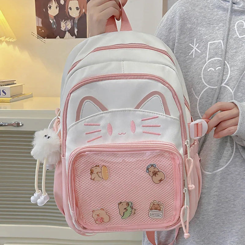 Pink neko backpack displayed by person holding them.