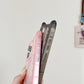 Two phone cases, one pink and one black, held against a plain background.