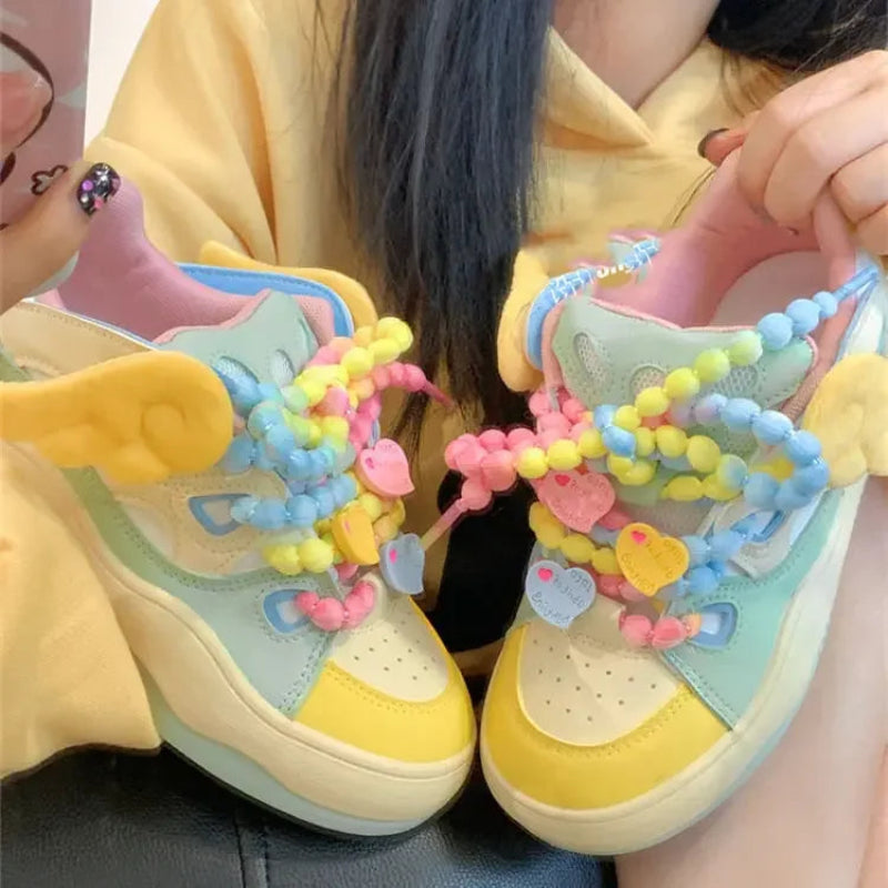 Angel on a rainbow platform sneakers, being displayed in front of a yellow hoodie 