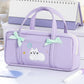Purple pencil bag with cat design and green bows on a reflective surface.
