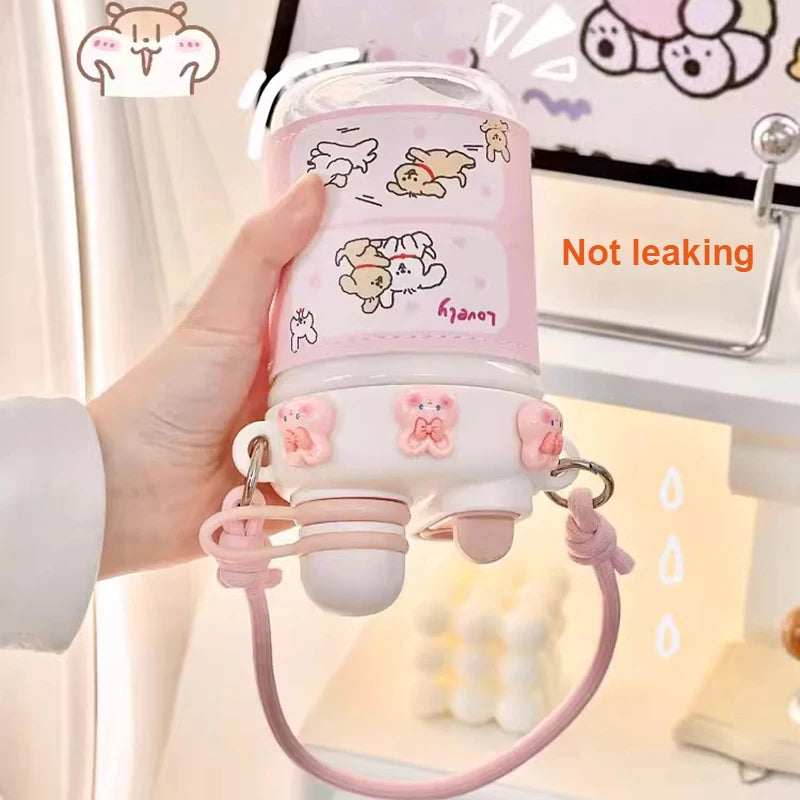 cute water bottle with cartoon designs held by hands against a blurred background.