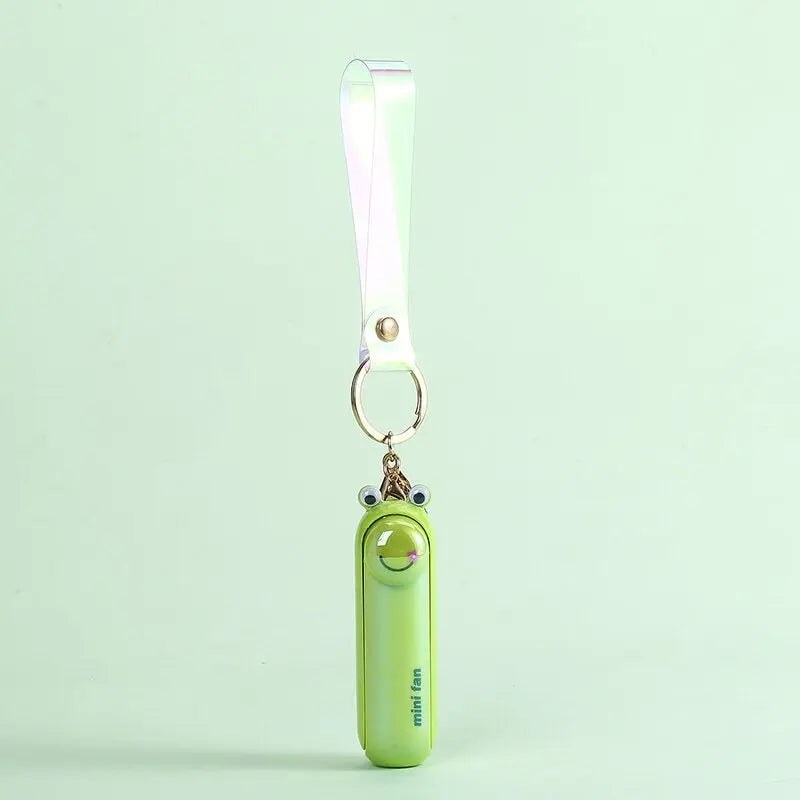 Green keychain frog fan on a light green background