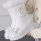 White winter boot with decorative elements held by a person wearing a beige coat.