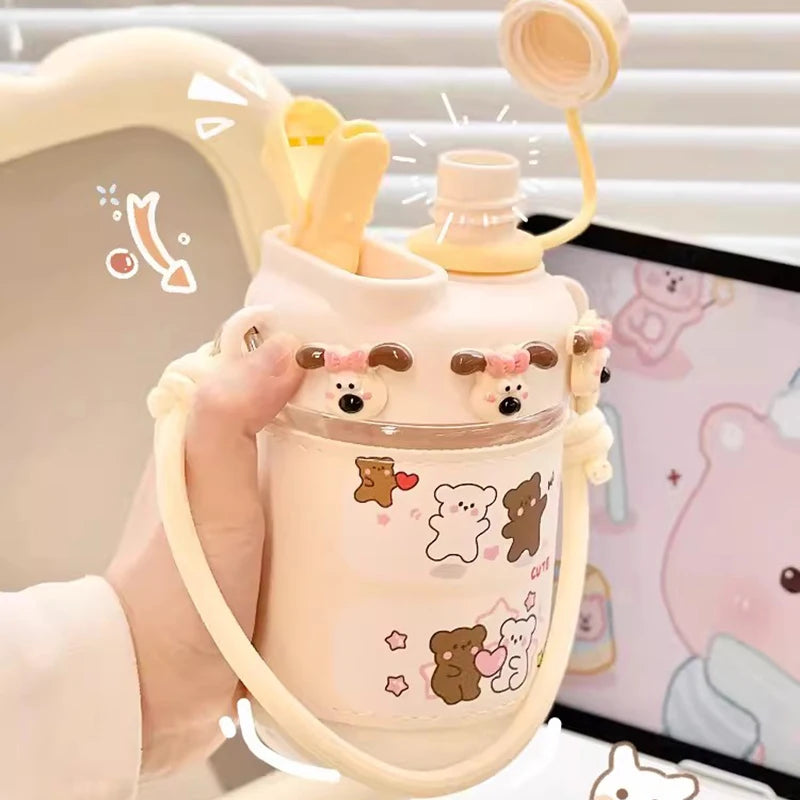 Cute water bottle with bear designs held by a hand, with a soft toy in the background.