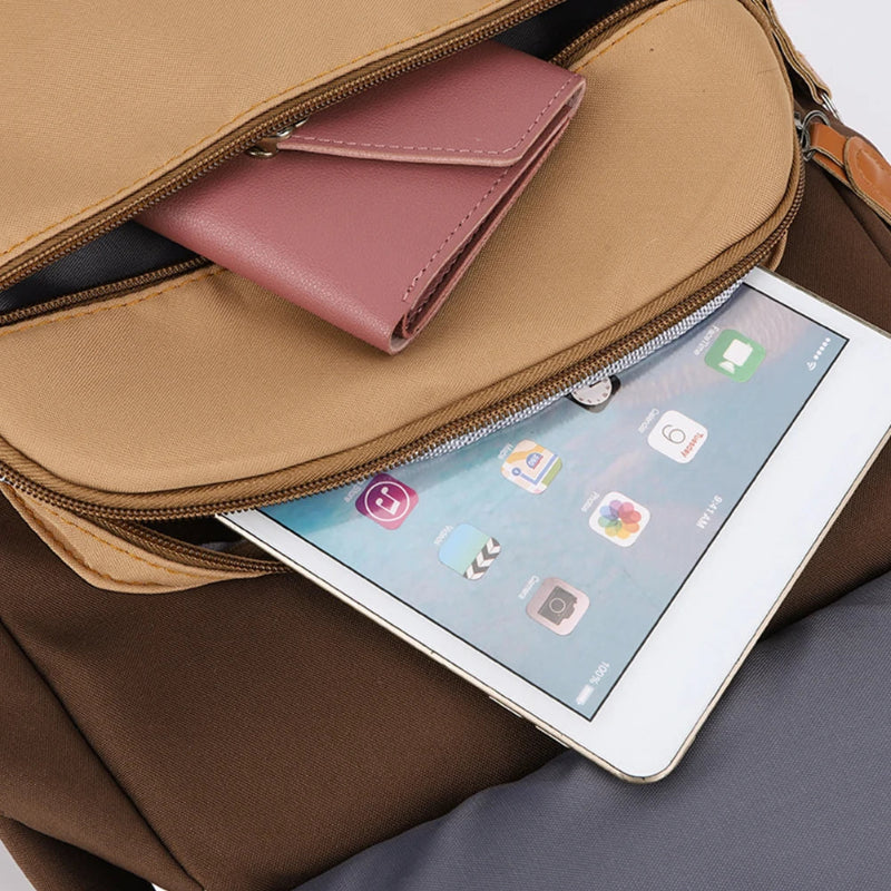 Open brown bag with a pink wallet and tablet displaying app icons.