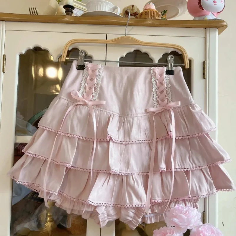 Pink ruffled dress on a hanger against a white cabinet background