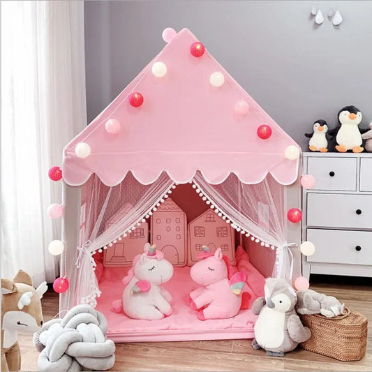 Pink children's play tent with toys and string lights in a room.