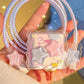 Star-shaped iphone charger cover with a clear case with stars held by a hand against a colorful background