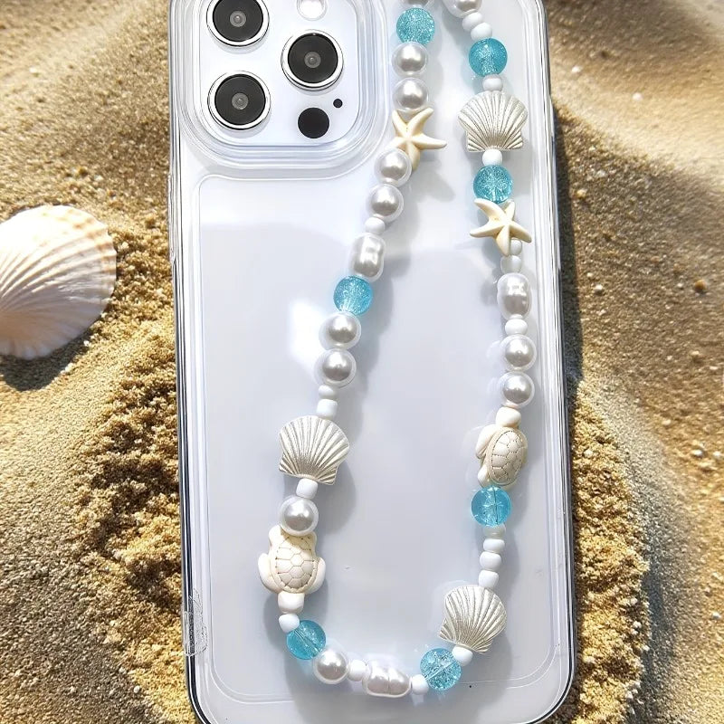 Mermaid treasure phone charm bracelet displayed on sandy beach