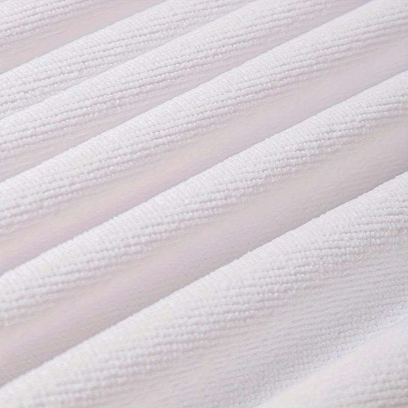 Close-up of textured white fabric with a subtle pattern on a light pink background