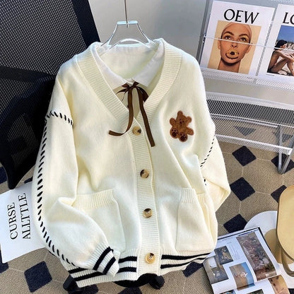 Sweet Teddy Bear Cardigan white edition with a bear sown into the chest area whilst the sleeves have large black stitches where they have been joined and black strips on the wrist cuffs and black and white trim. 