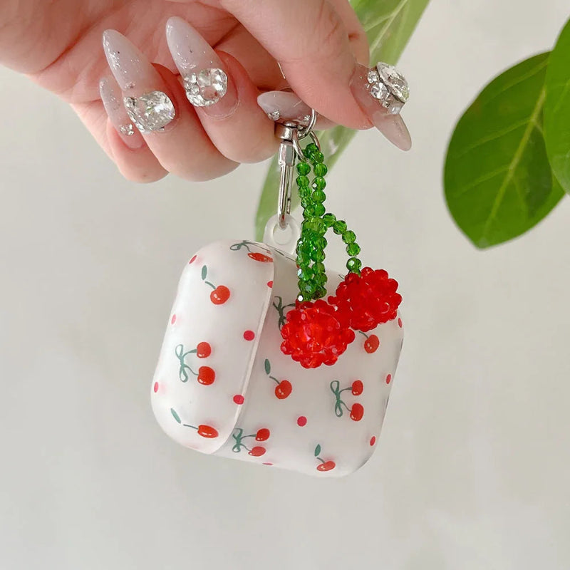 White case with cherry design held by a hand with decorative nails.