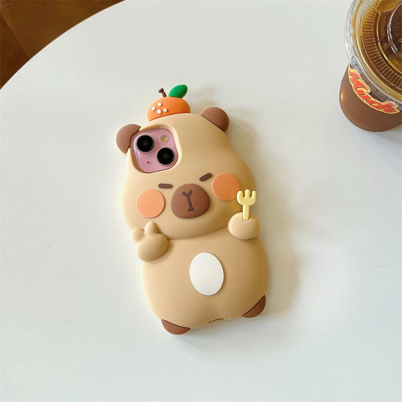 Phone case shaped like a cute capybara with a small orange on its head on a white surface