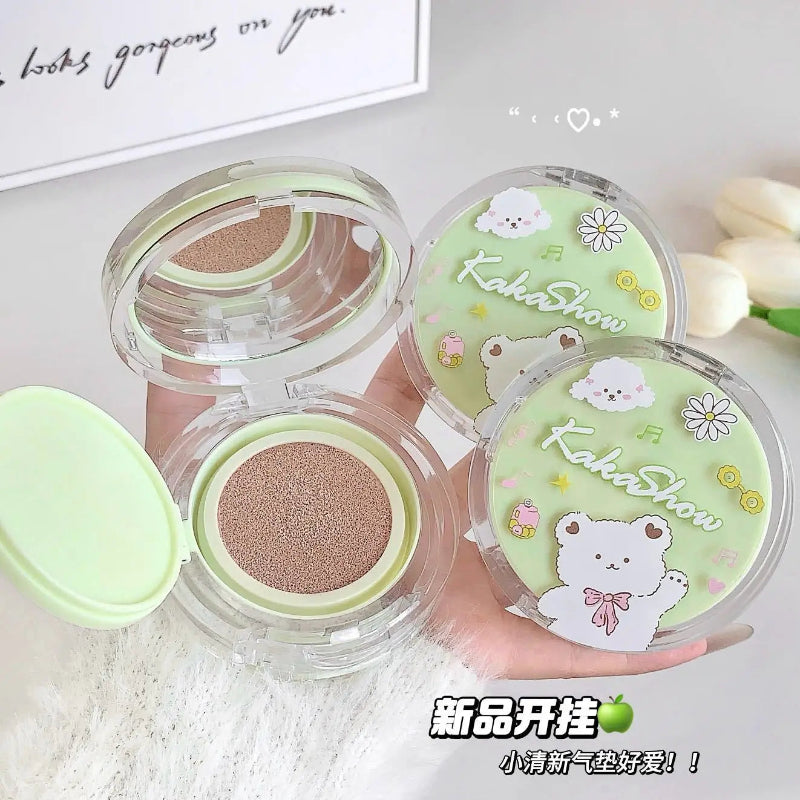 Makeup compact with green lid featuring a bear design on a light background