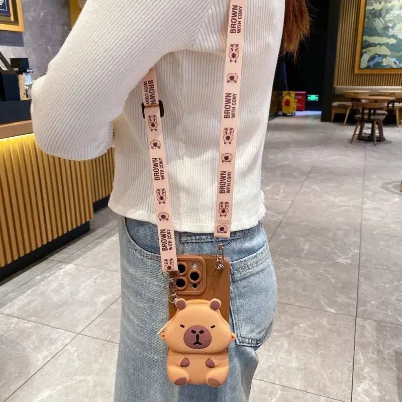 Person wearing a white sweater with a Capybara-themed phone case and strap.
