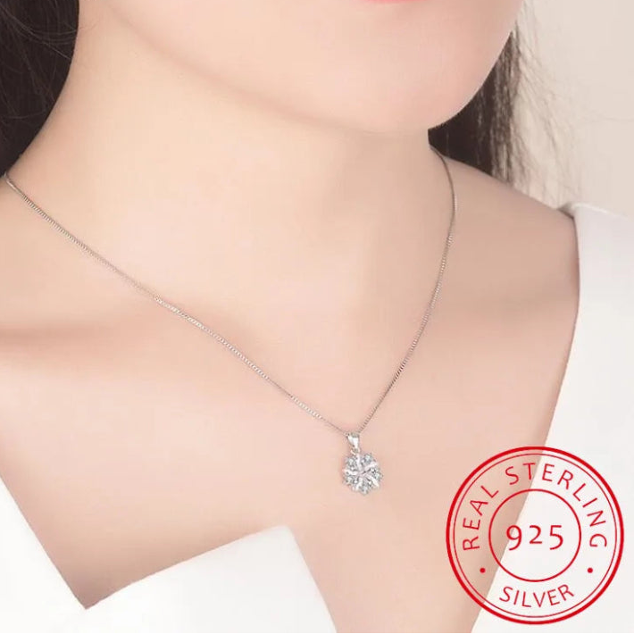 a women is wearing Sakura Cherry Blossom Necklace light pink version, displaying where the pendant sits on her lower neck area.