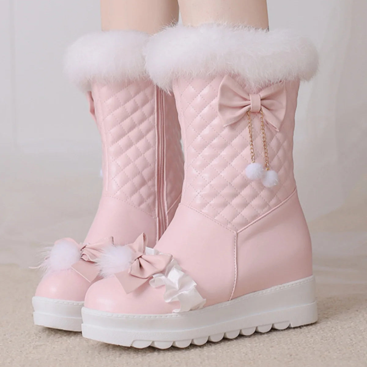 Pink winter boots with white fur lining and decorative bows on a neutral background