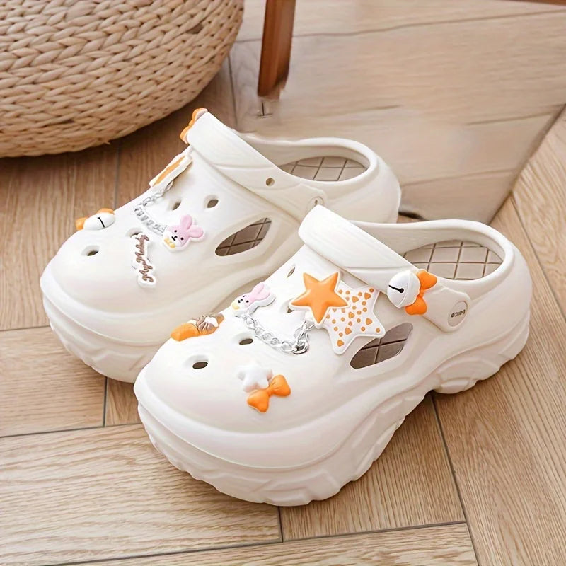 White sandals with decorative stars and bows charms on a wooden floor