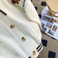 Sweet Teddy Bear Cardigan white edition with a bear sown into the chest area whilst the sleeves have large black stitches where they have been joined and black strips on the wrist cuffs and black and white trim, this image is showing a close up of the pocket on the front of the cardigan and the design.