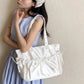 Woman holding a white bag against a beige wall